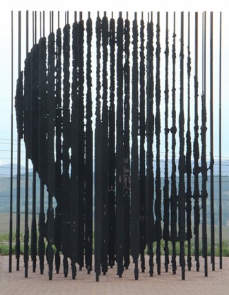 Het Mandela Monument in Howick bestaat uit tientallen ijzeren palen die voor en achter elkaar staan. Je krijgt het portret van Mandela enkel te zien als je op exact de juiste plek gaat staan.